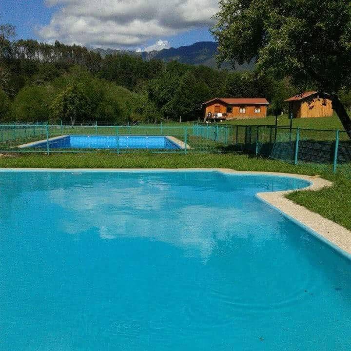 Piscinas de Bajo Los Luengo, rodeadas de áreas verdes y cabañas de madera